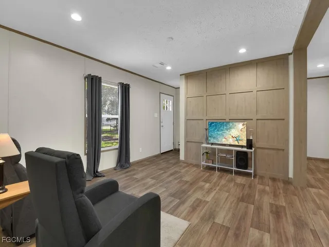 a kitchen with kitchen island granite countertop a refrigerator cabinets and wooden floor