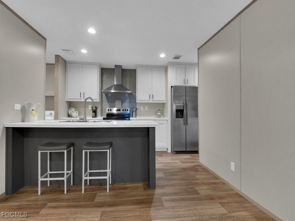 1079 Summerall Road LaBelle, FL 33935 - Photo 5 of 26 a kitchen with kitchen island granite countertop a refrigerator cabinets and wooden floor