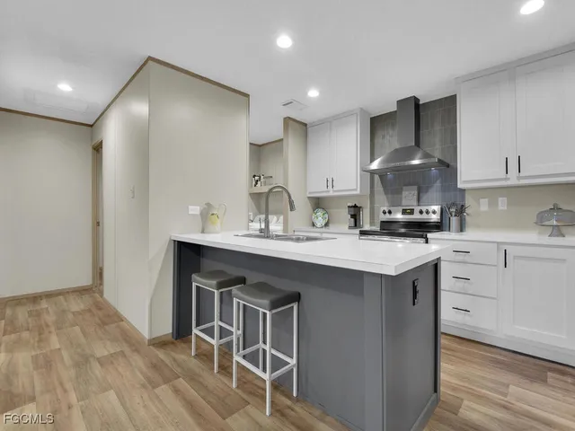 a kitchen with stainless steel appliances granite countertop a sink a stove a refrigerator and cabinets