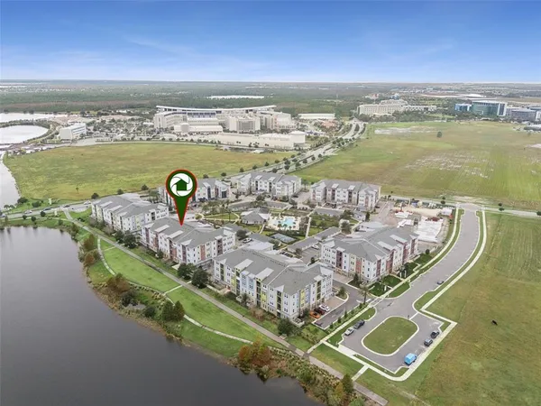 a kitchen with stainless steel appliances kitchen island granite countertop a sink a stove a refrigerator and island with wooden floor