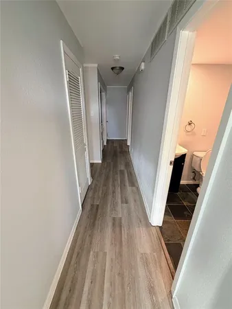 a view of a hallway with wooden floor and staircase