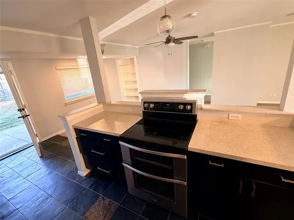 a kitchen with a stove a sink and wooden floor