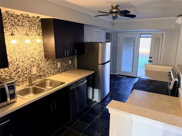 a kitchen with stainless steel appliances a sink stove and refrigerator