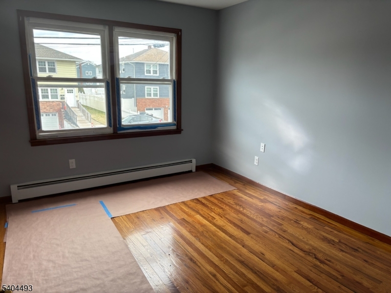 892 Hobson Street Union, NJ 07083 - Photo 7 of 14 an empty room with wooden floor and windows