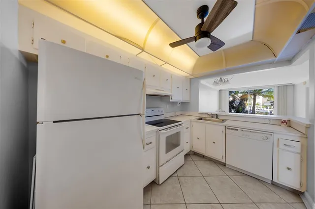 a kitchen with white cabinets and white appliances