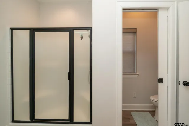a bathroom with a granite countertop toilet and a shower