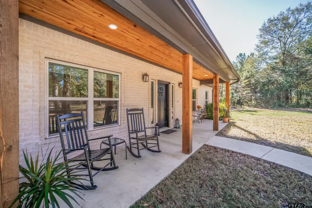 a kitchen with stainless steel appliances a stove a sink dishwasher a refrigerator with a dining table and chairs