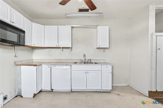 a kitchen with granite countertop a sink stainless steel appliances and cabinets