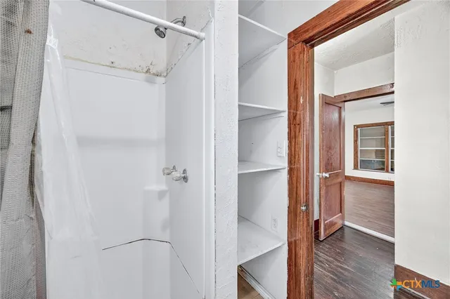 an empty room with closet and a chandelier fan