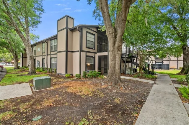 a view of a brick house with many windows next to a yard