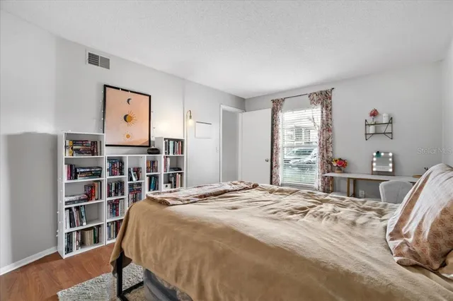 a bedroom with a bed a book shelf and a window