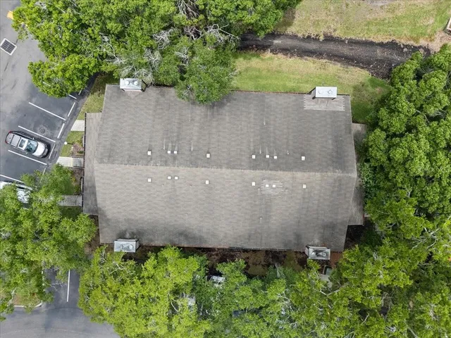 an aerial view of a house with a yard and a large tree