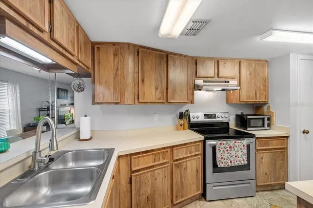 a kitchen with kitchen island granite countertop a sink stainless steel appliances and cabinets