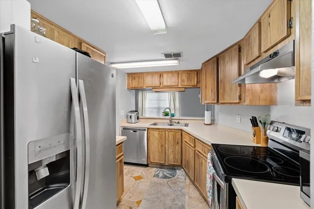 a kitchen with a sink a refrigerator and cabinets