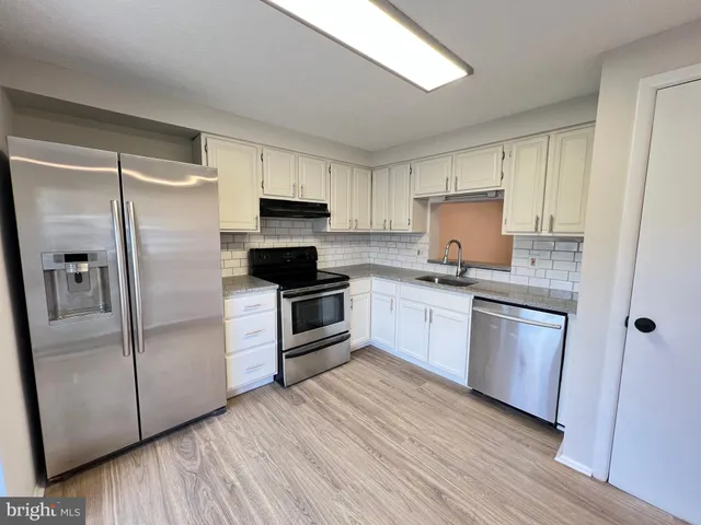 a kitchen with a refrigerator stove and sink