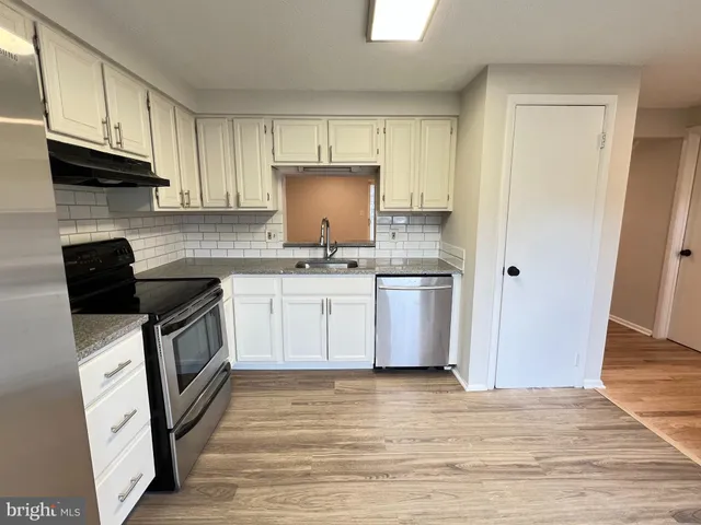 a kitchen with a sink a stove and a refrigerator