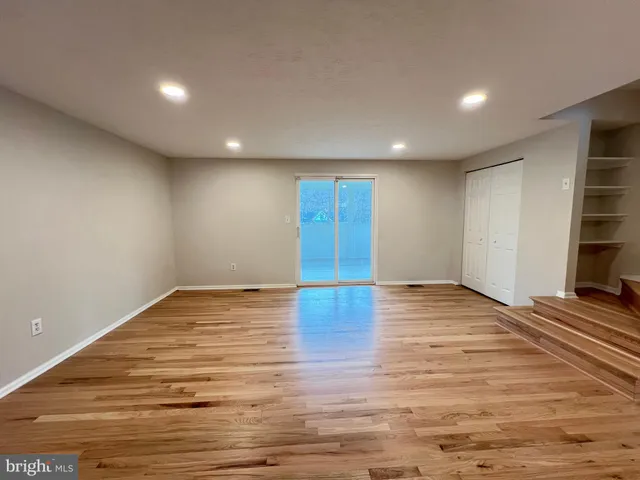 a view of empty room with wooden floor and chair