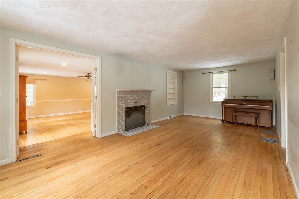 16 Michael Road Bourne, MA 02559 - Photo 17 of 41 a view of empty room with wooden floor and fireplace