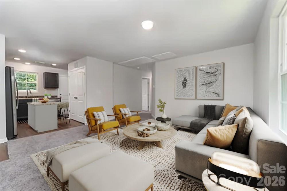 a living room with furniture and kitchen view