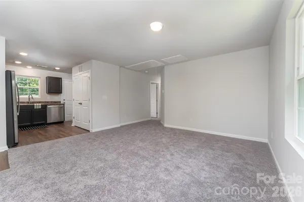 an empty room with a kitchen and a sink
