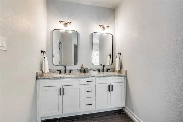 a bathroom with double vanity sinks and a mirror