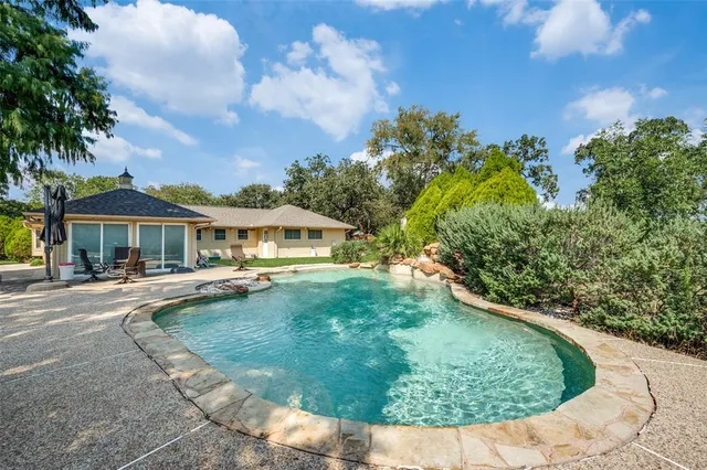 a view of a house with swimming pool and sitting area