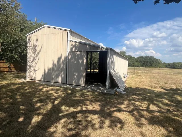 a view of a house with backyard and trees