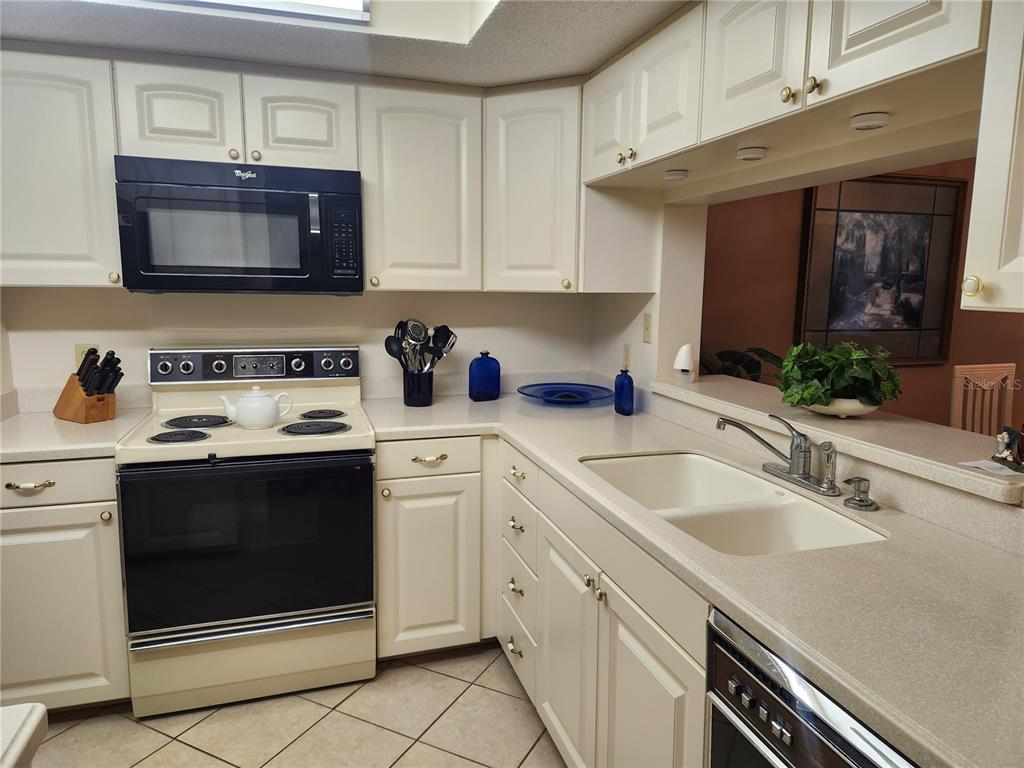 6503 Stone River Road, Unit 109 Bradenton, FL 34203 - Photo 6 of 39 a kitchen with stainless steel appliances granite countertop a stove microwave and sink