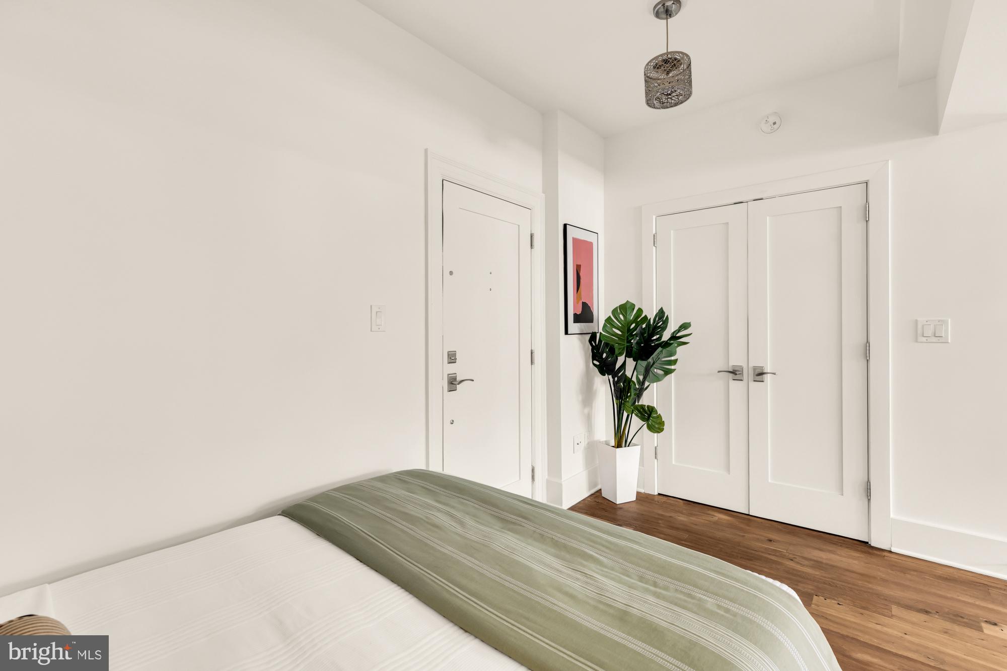 1910 Kalorama Road Northwest, Unit 302 Washington, DC 20009 - Photo 8 of 28 a bedroom with a bed and a potted plant
