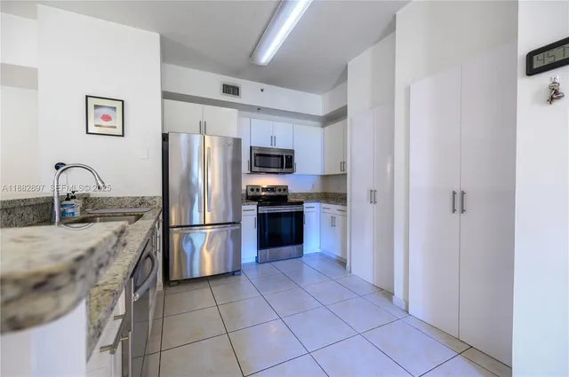 a kitchen with granite countertop a refrigerator and a sink