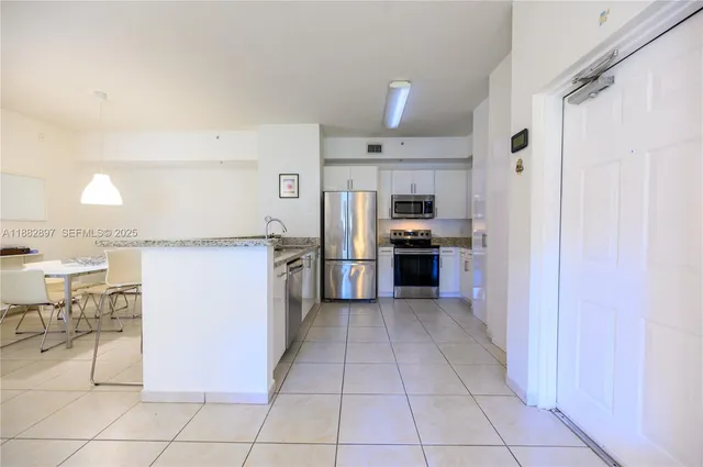 a kitchen with stainless steel appliances granite countertop a refrigerator and a sink