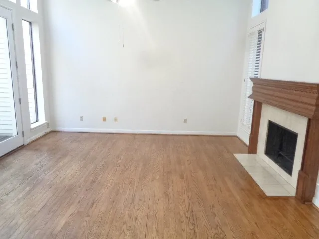 an empty room with wooden floor and fireplace