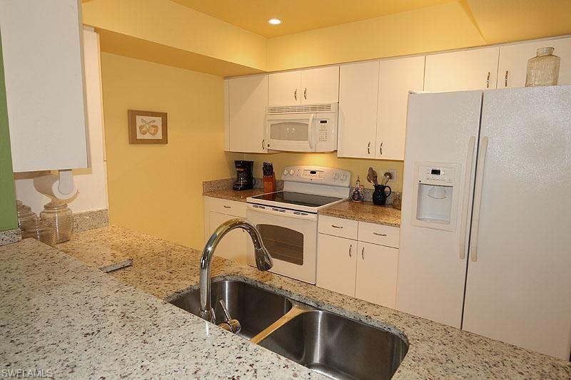 a kitchen with stainless steel appliances a refrigerator sink and cabinets