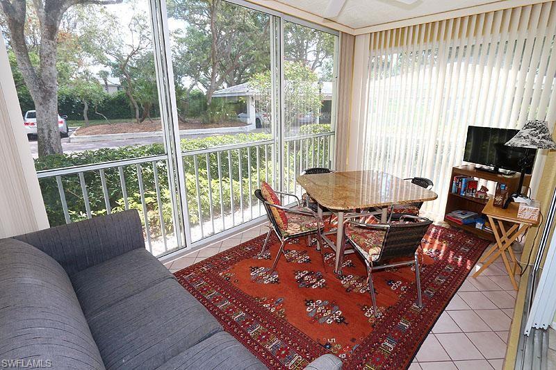 784 Willowbrook Drive, Unit 601 Naples, FL 34108 - Photo 12 of 20 a living room with furniture and a flat screen tv