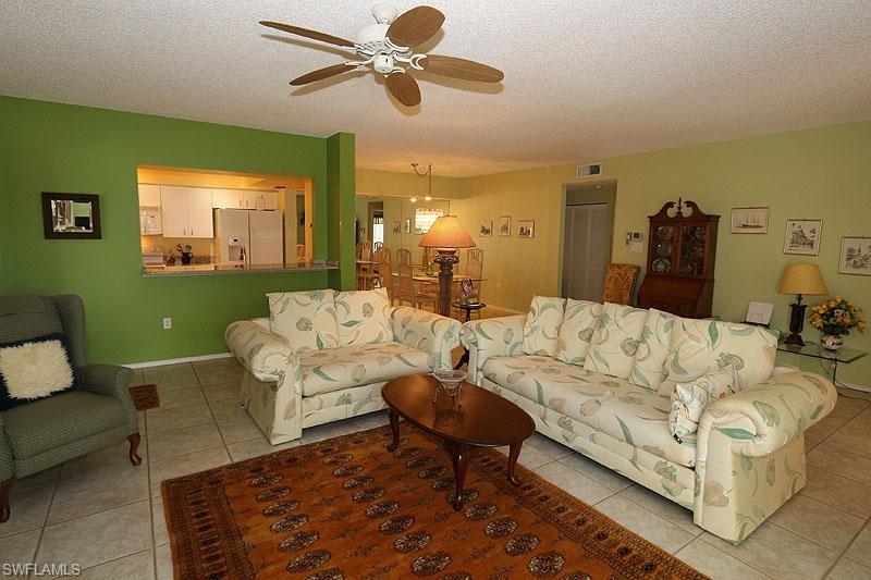 784 Willowbrook Drive, Unit 601 Naples, FL 34108 - Photo 15 of 20 a living room with furniture and a wooden floor