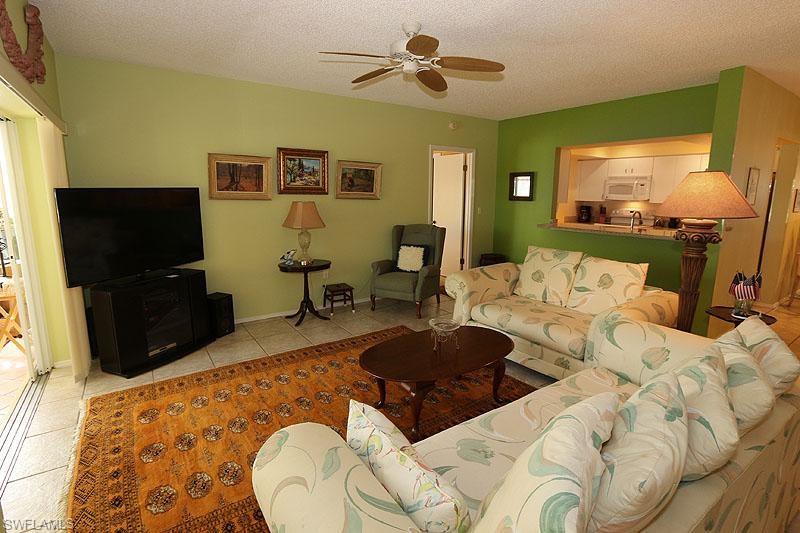784 Willowbrook Drive, Unit 601 Naples, FL 34108 - Photo 16 of 20 a living room with furniture a flat screen tv and a fireplace