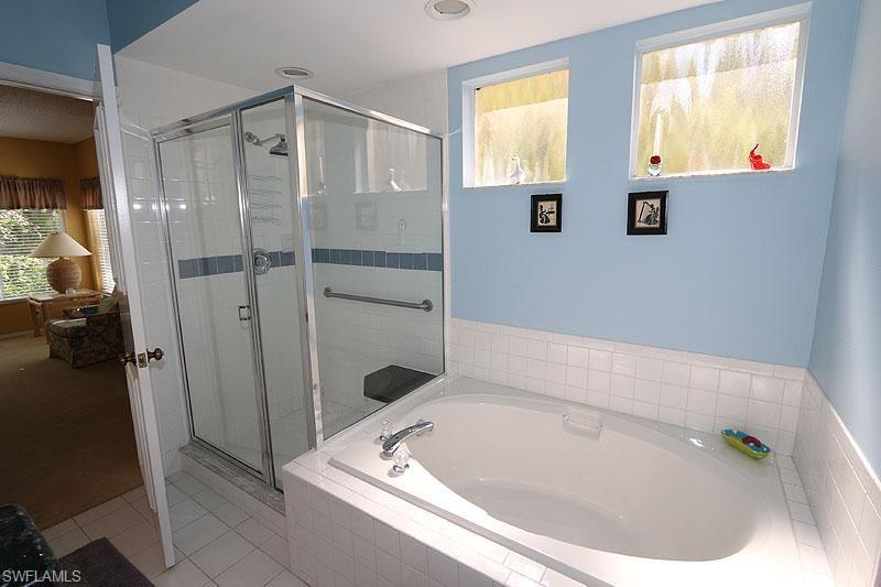 784 Willowbrook Drive, Unit 601 Naples, FL 34108 - Photo 18 of 20 a bathroom with a tub and a shower
