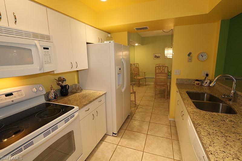784 Willowbrook Drive, Unit 601 Naples, FL 34108 - Photo 2 of 20 a kitchen with a sink and refrigerator