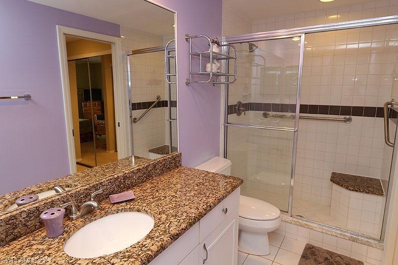 784 Willowbrook Drive, Unit 601 Naples, FL 34108 - Photo 8 of 20 a bathroom with a granite countertop sink toilet and shower