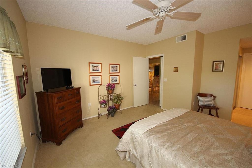 784 Willowbrook Drive, Unit 601 Naples, FL 34108 - Photo 10 of 20 a bedroom with a bed and a flat screen tv