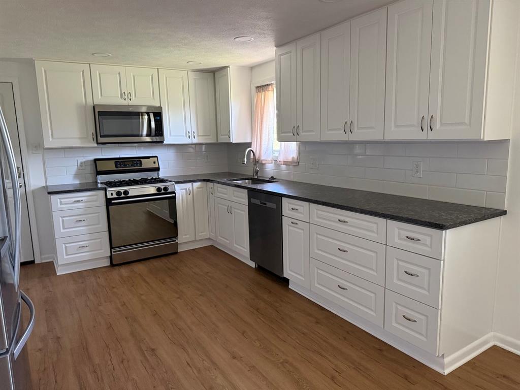 27 Corbett Avenue Irwin, PA 15642 - Photo 11 of 39 a kitchen with stainless steel appliances granite countertop a stove a sink and a microwave