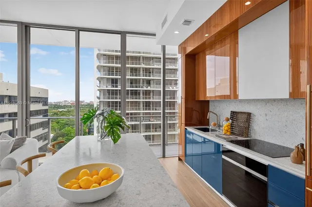 a view of a kitchen with kitchen island a large window cabinets and stainless steel appliances