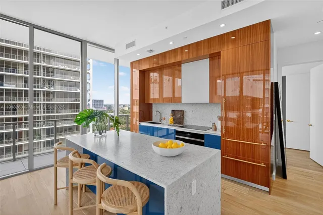 a kitchen with granite countertop a refrigerator a stove a sink and dishwasher with wooden floor