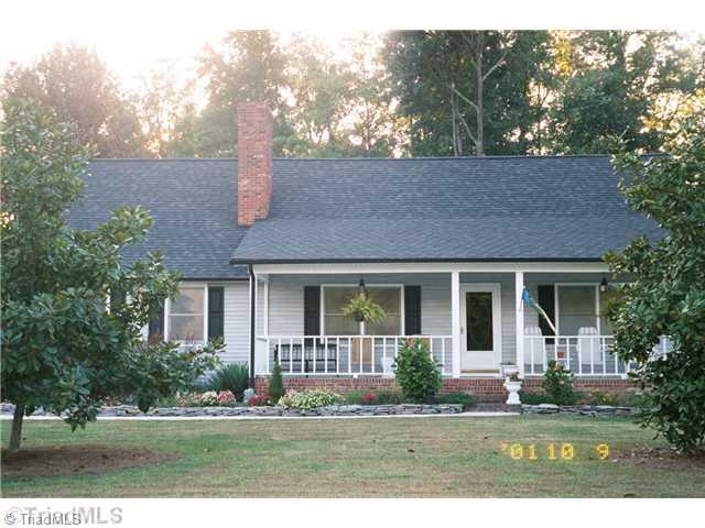 7026 Penman Road High Point, NC 27263 - Photo 3 of 16 Exterior Front. Relax and enjoy yourself. this home features remodeled baths, water system, new custom built oak cabinets with ss appliances, security system, sprinkler system, fenced rear yard with back patio area, and brick fireplace with gas logs.