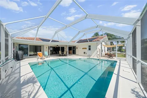 a view of a patio with couches table and chairs under an umbrella
