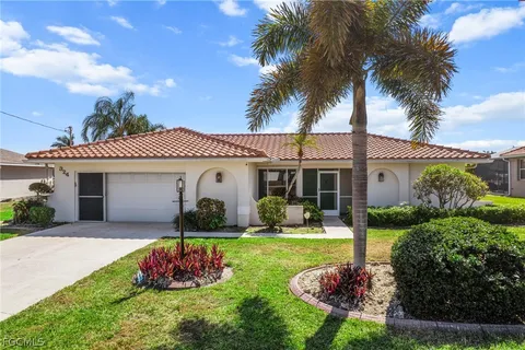 a front view of a house with a yard and potted plants