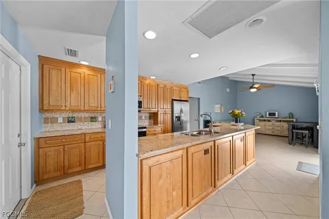 a kitchen with stainless steel appliances kitchen island granite countertop a table and chairs in it