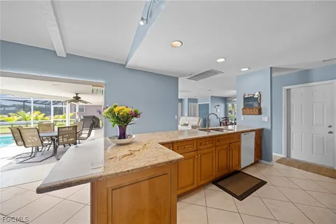 a kitchen with stainless steel appliances granite countertop a stove a sink dishwasher and a refrigerator with wooden cabinets