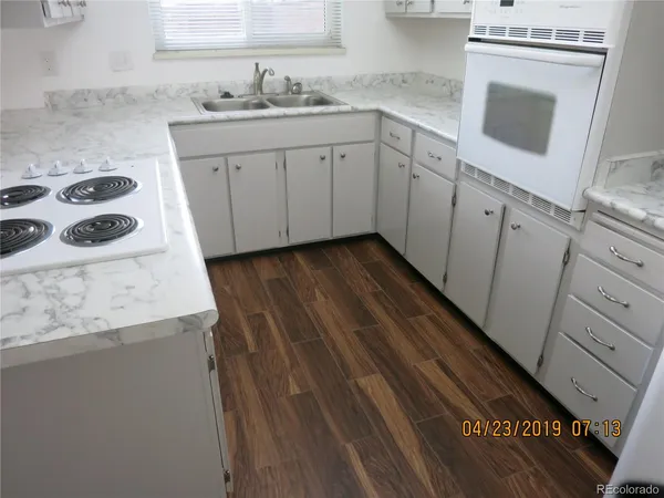 a kitchen with granite countertop a sink stove and refrigerator