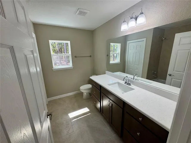 a bathroom with a double vanity sink toilet and a mirror